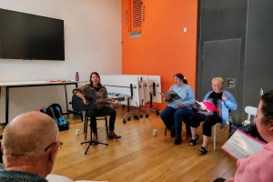 Debs leads the inaugural music group on guitar